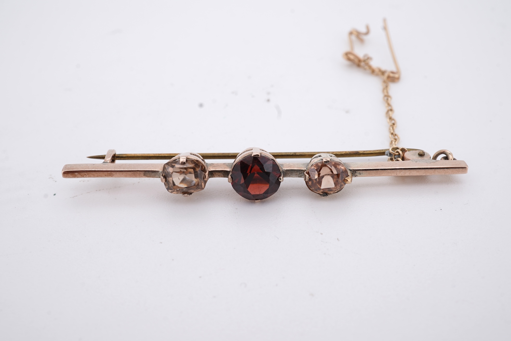 A Victorian yellow metal, amethyst and garnet cluster set brooch, 22mm, an early 20th century yellow metal and seed pearl set heart shaped locket, a yellow metal, garnet and zircon set three stone bar brooch and a tortoi
